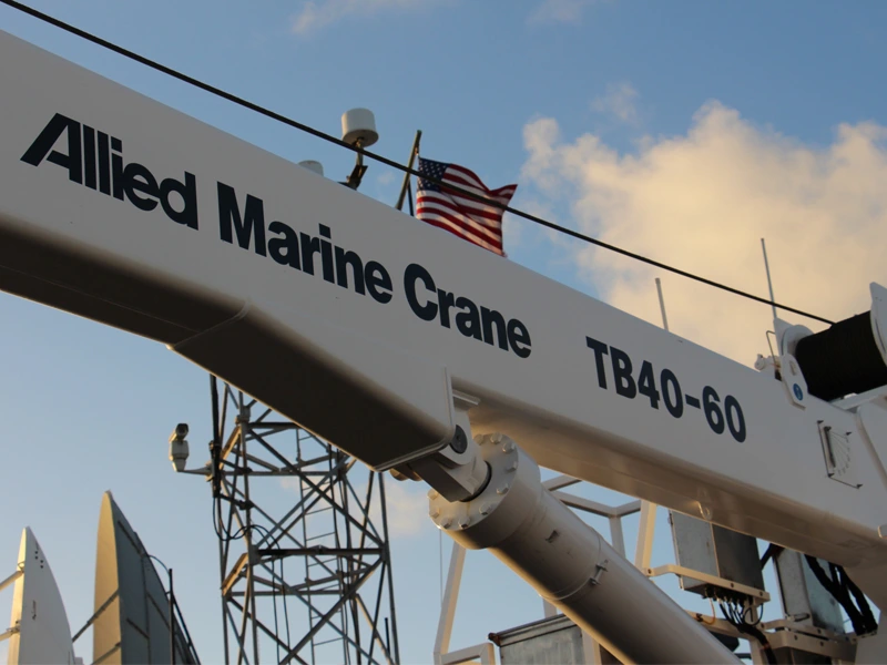 Zoomed in shot of Allied Marince Crane logo on Crane arm with American Flag in background