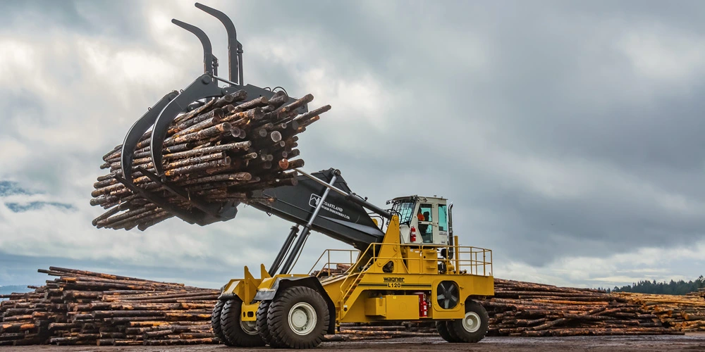 Yellow Wagner Logstacker with a raised load of logs