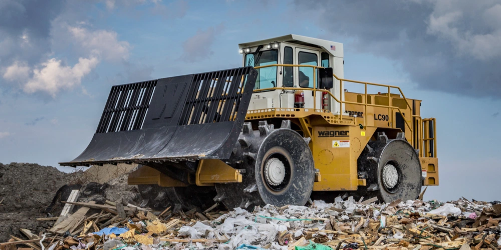 Yellow Wagner Landfill Compactor on pile